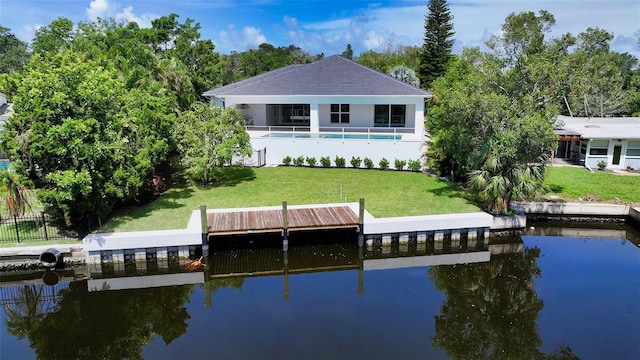 dock area with a water view and a yard