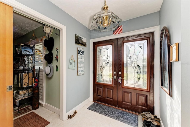 entryway with french doors and a chandelier