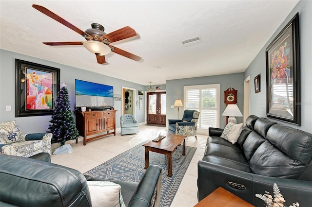 living room with light tile patterned flooring, ceiling fan, a textured ceiling, and french doors