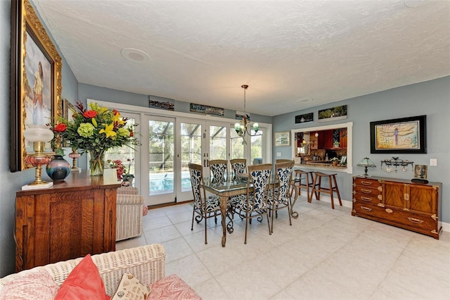 dining space featuring a textured ceiling and a chandelier