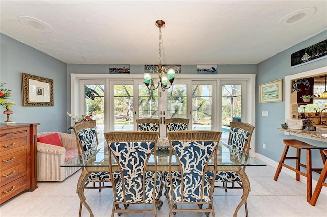 dining area featuring a healthy amount of sunlight, a chandelier, and light tile patterned floors