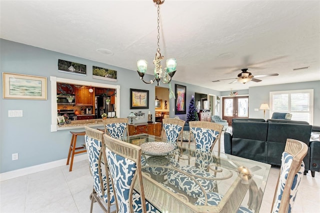 tiled dining room with ceiling fan with notable chandelier and a textured ceiling