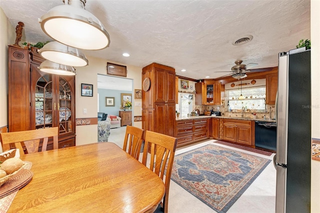 tiled dining space with ceiling fan, indoor wet bar, and a textured ceiling