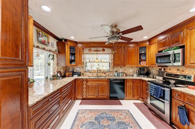 kitchen featuring pendant lighting, sink, appliances with stainless steel finishes, backsplash, and light stone countertops