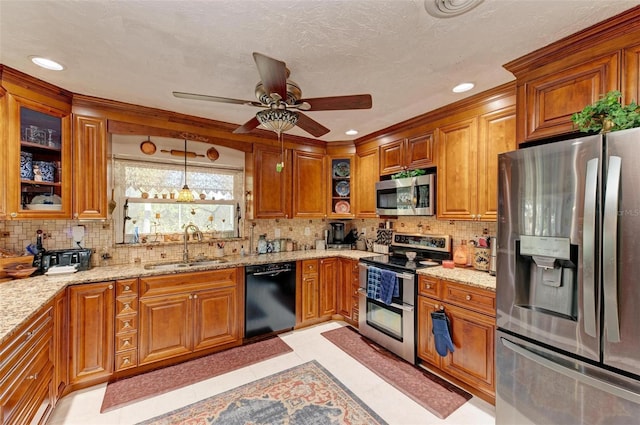 kitchen featuring sink, appliances with stainless steel finishes, hanging light fixtures, light stone countertops, and decorative backsplash