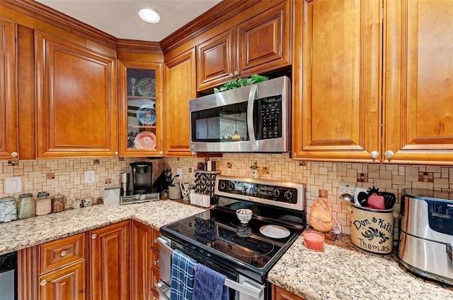 kitchen with light stone counters, appliances with stainless steel finishes, and tasteful backsplash