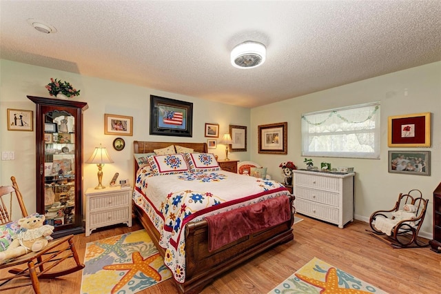 bedroom featuring a textured ceiling and light hardwood / wood-style floors