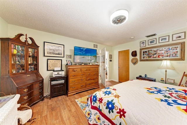 bedroom featuring light hardwood / wood-style flooring and a textured ceiling