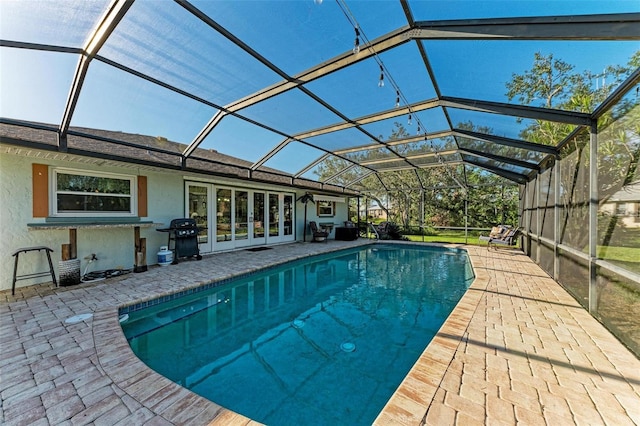 view of swimming pool featuring grilling area, a lanai, and a patio area