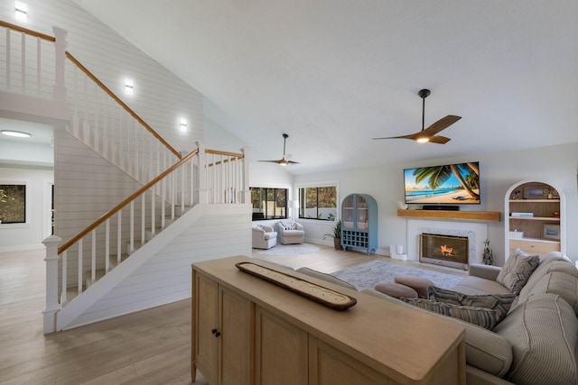 living room featuring ceiling fan, light hardwood / wood-style flooring, and high vaulted ceiling