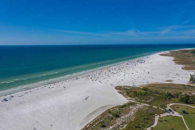 drone / aerial view featuring a water view and a view of the beach