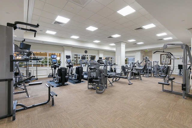 exercise room featuring a paneled ceiling and light colored carpet