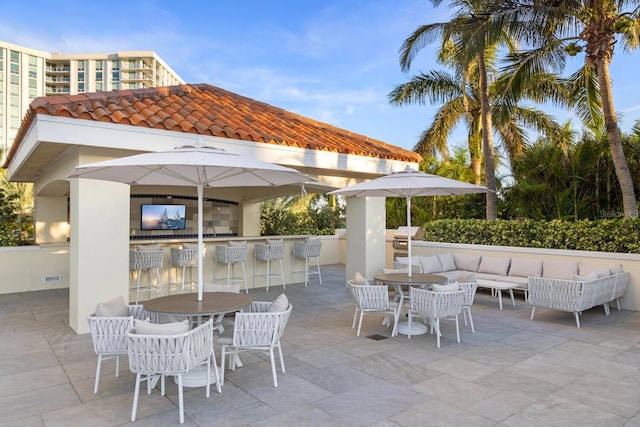 view of patio / terrace with outdoor lounge area, a balcony, and a bar