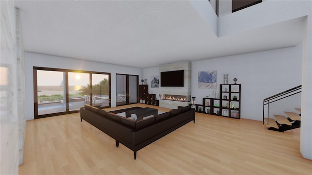 living room featuring a textured ceiling, light hardwood / wood-style floors, and a fireplace