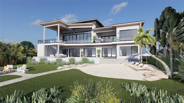 rear view of house with a patio area, a yard, and a balcony