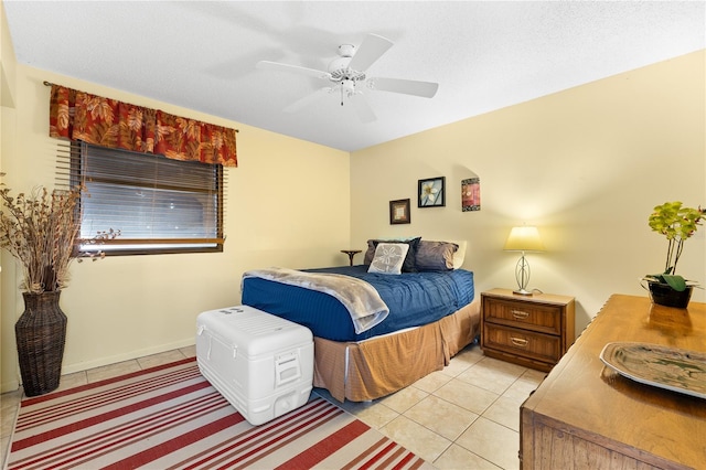 bedroom featuring ceiling fan, light tile patterned flooring, and a textured ceiling