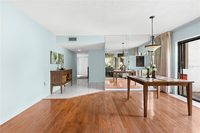 dining space featuring a textured ceiling and light hardwood / wood-style flooring