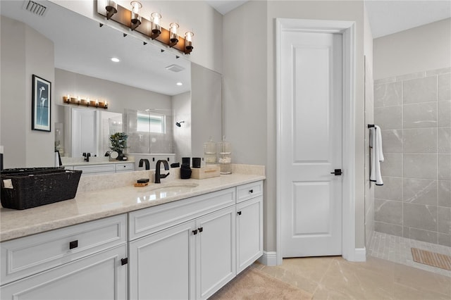 bathroom featuring vanity and tiled shower