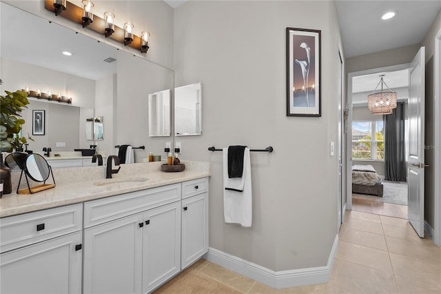 bathroom featuring vanity, an inviting chandelier, and tile patterned floors