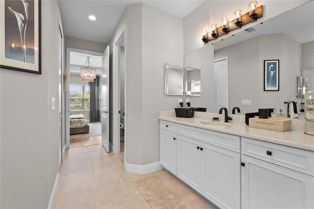 bathroom featuring tile patterned floors, vanity, toilet, and a notable chandelier