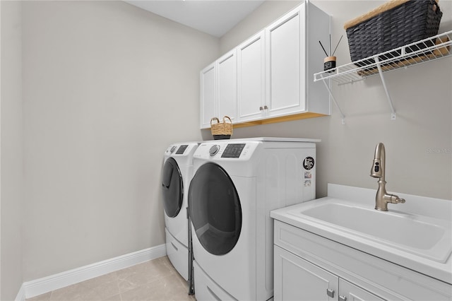 washroom featuring cabinets, light tile patterned floors, washing machine and dryer, and sink