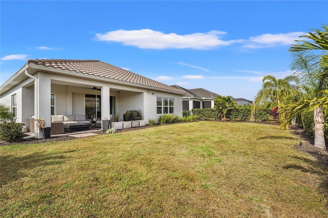 back of house featuring ceiling fan, a yard, and an outdoor hangout area