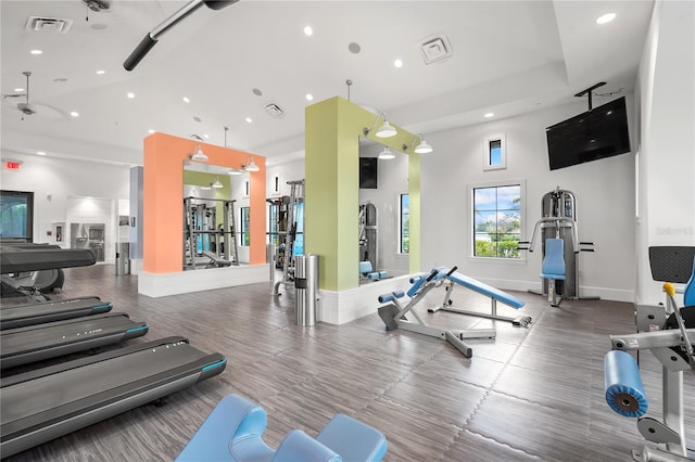 exercise room featuring a towering ceiling