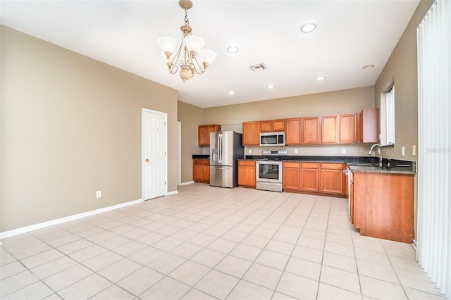 kitchen featuring pendant lighting, sink, light tile patterned floors, appliances with stainless steel finishes, and a chandelier