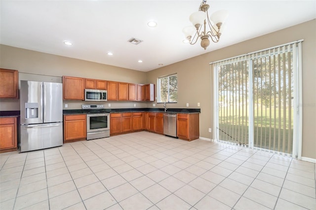 kitchen with decorative light fixtures, light tile patterned floors, stainless steel appliances, and an inviting chandelier