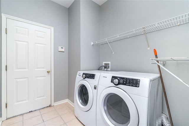 laundry area with washer and dryer and light tile patterned floors