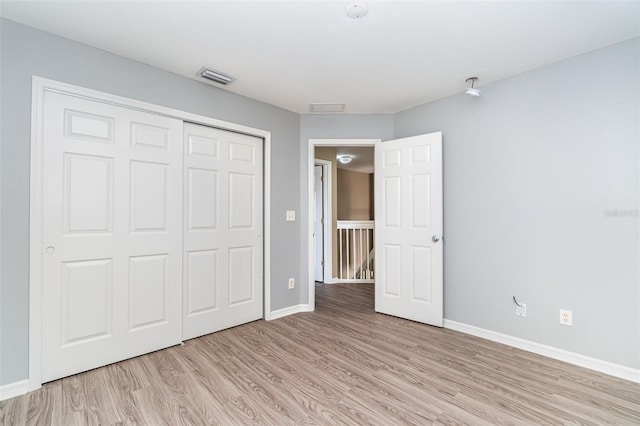 unfurnished bedroom featuring light wood-type flooring and a closet