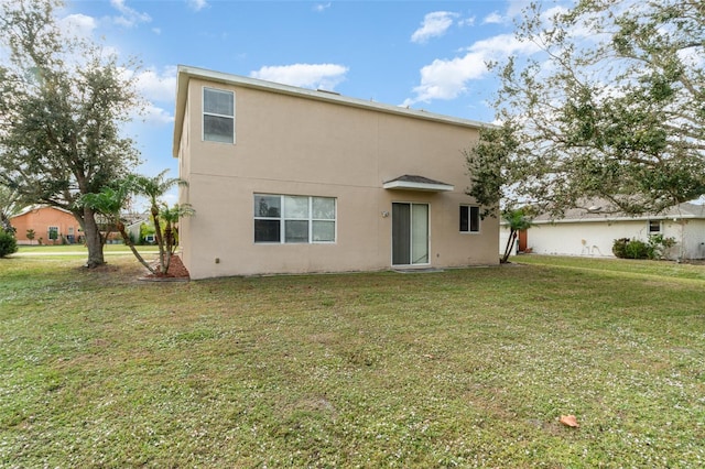 rear view of property featuring a lawn