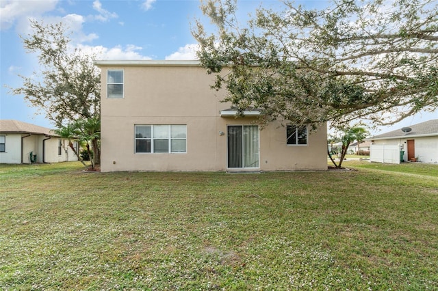 rear view of house featuring a yard