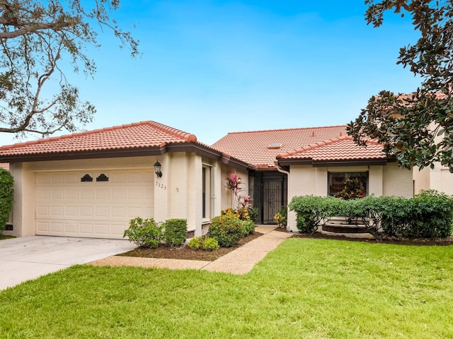 mediterranean / spanish home featuring a front lawn and a garage