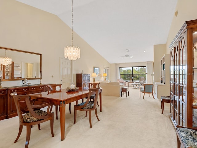 dining area with light carpet, ceiling fan with notable chandelier, and high vaulted ceiling