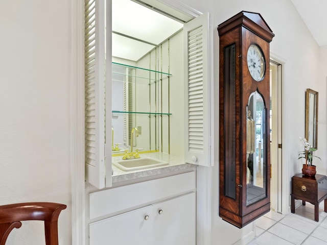 tiled foyer featuring sink and lofted ceiling