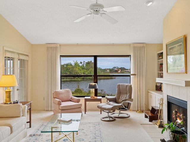 living room featuring a fireplace, a healthy amount of sunlight, a water view, and light colored carpet