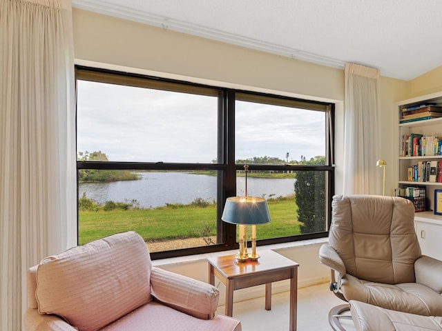 living area with crown molding and a water view