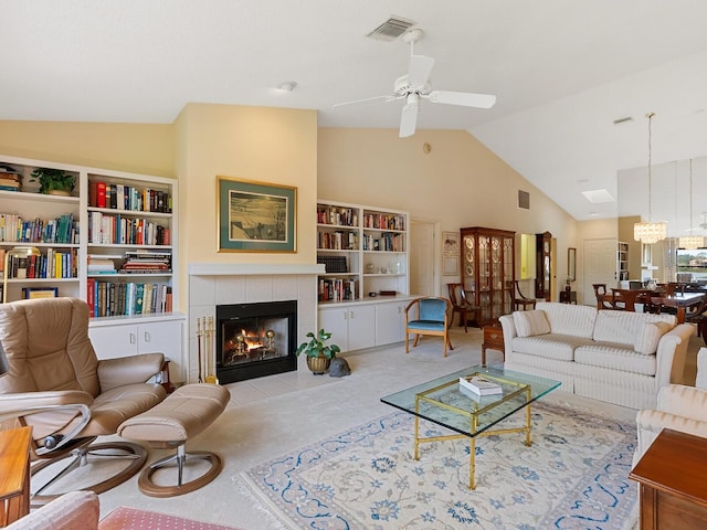 carpeted living room with ceiling fan with notable chandelier, lofted ceiling, and a tiled fireplace