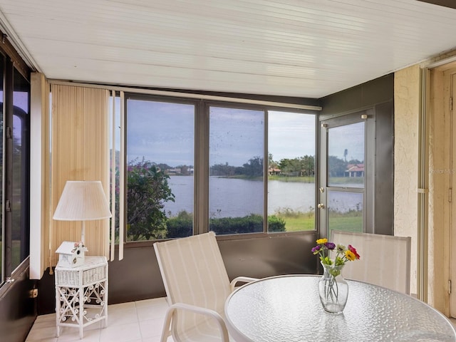 sunroom featuring a water view