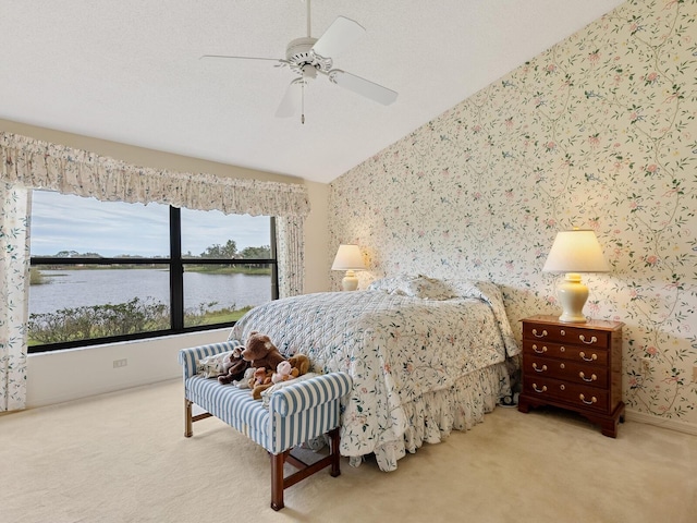 carpeted bedroom featuring ceiling fan, lofted ceiling, and a water view