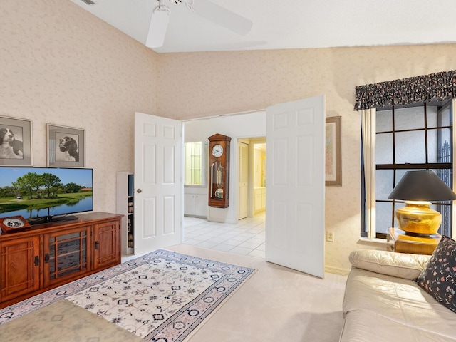 tiled living room featuring ceiling fan and a towering ceiling