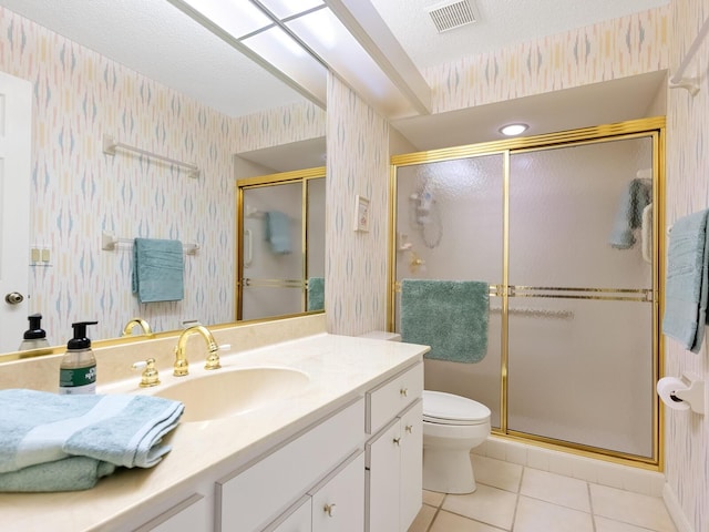 bathroom featuring walk in shower, vanity, tile patterned flooring, toilet, and a textured ceiling