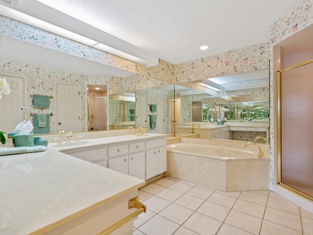 bathroom with a textured ceiling, tile patterned floors, vanity, and independent shower and bath