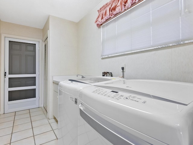 laundry room featuring cabinets, light tile patterned floors, and washer and dryer