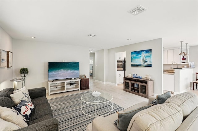 living room with sink and light hardwood / wood-style flooring