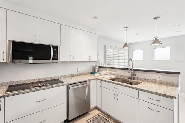 kitchen featuring white cabinets, pendant lighting, sink, and stainless steel appliances