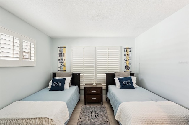 bedroom with a textured ceiling and light hardwood / wood-style floors