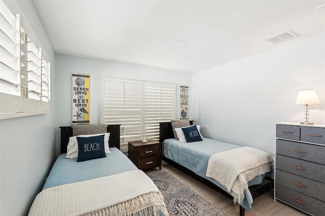 bedroom featuring a textured ceiling and light wood-type flooring