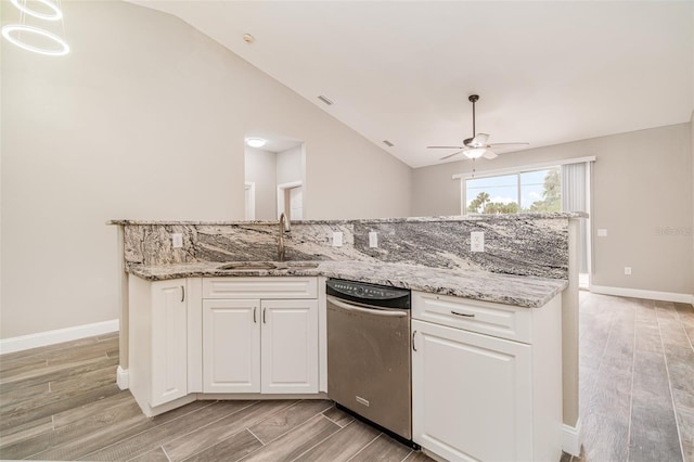 kitchen featuring ceiling fan, sink, light stone counters, lofted ceiling, and white cabinets